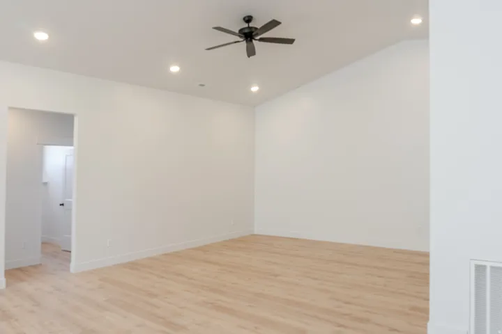 Empty room featuring light wood-style flooring, ceiling fan, and recessed lighting