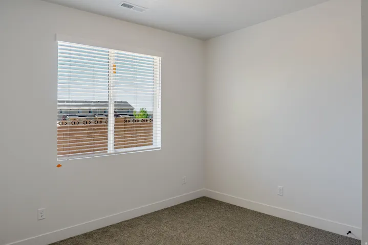 Carpeted spare room with baseboards