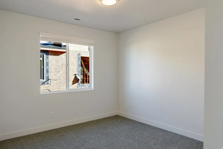 Carpeted spare room featuring baseboards