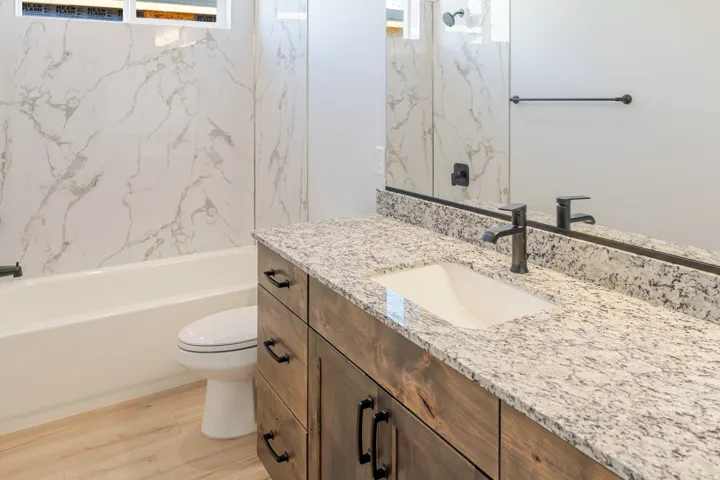 Full bath featuring vanity, light wood-style floors, and shower / tub combination