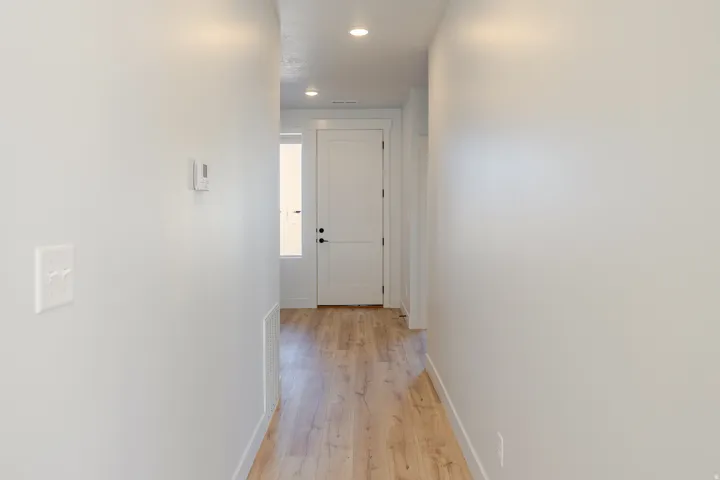 Hallway featuring light wood finished floors and recessed lighting