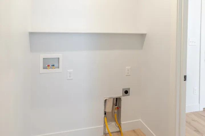Laundry room with light wood finished floors and hookup for a washing machine