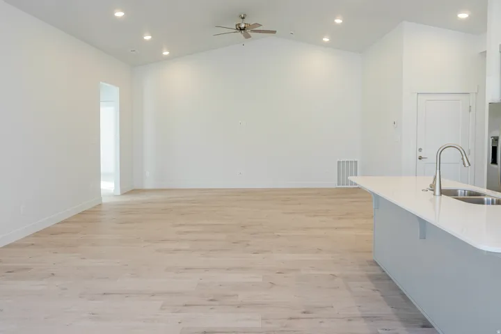 Kitchen featuring recessed lighting, light wood-style flooring, a ceiling fan, a breakfast bar area, and lofted ceiling