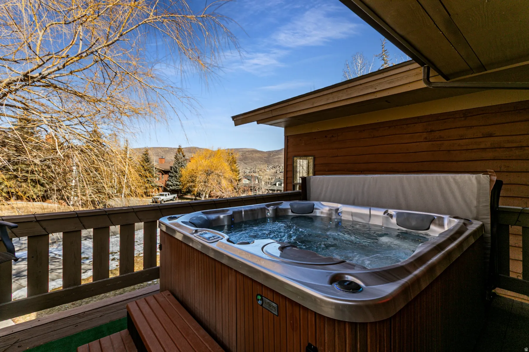 Wooden deck featuring a hot tub and a mountain view