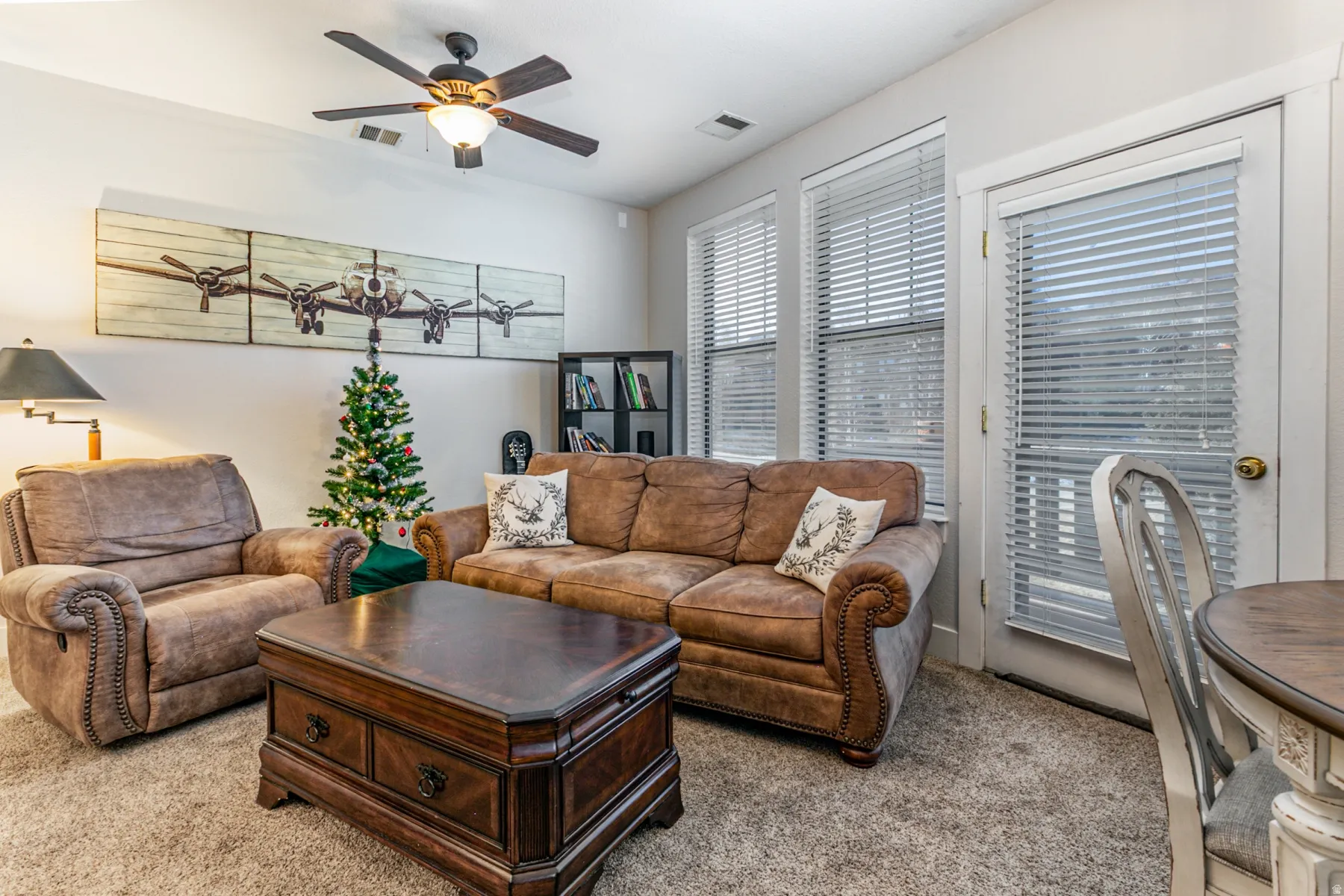 Carpeted living room with a ceiling fan
