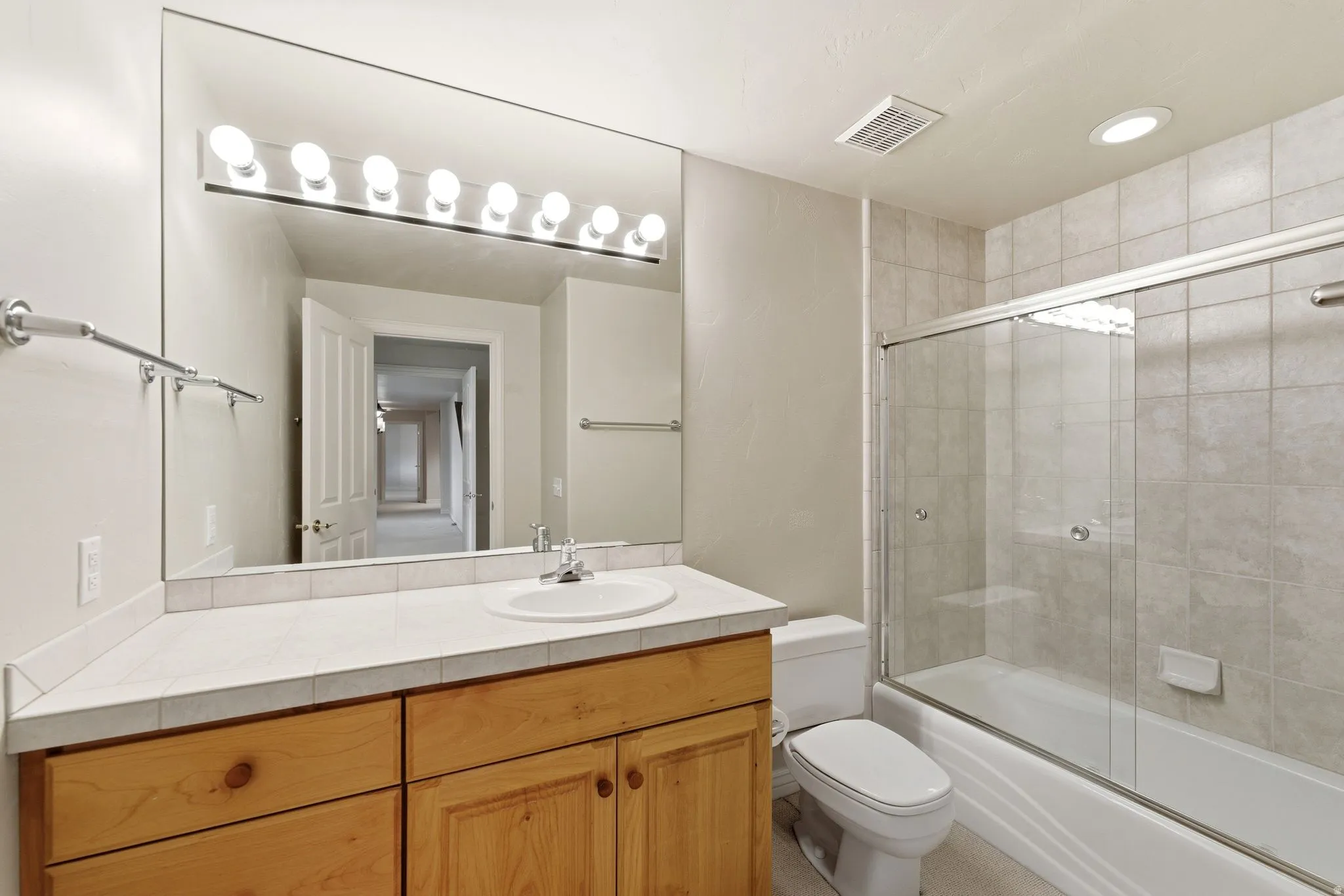 Full bathroom with enclosed tub / shower combo, vanity, and recessed lighting