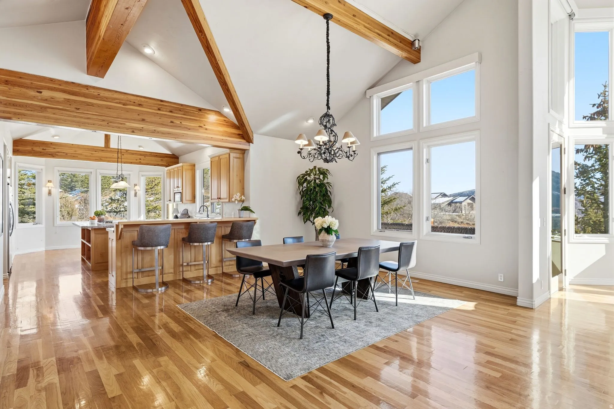 Dining space featuring suspended lighting, light wood-style flooring, and lofted ceiling