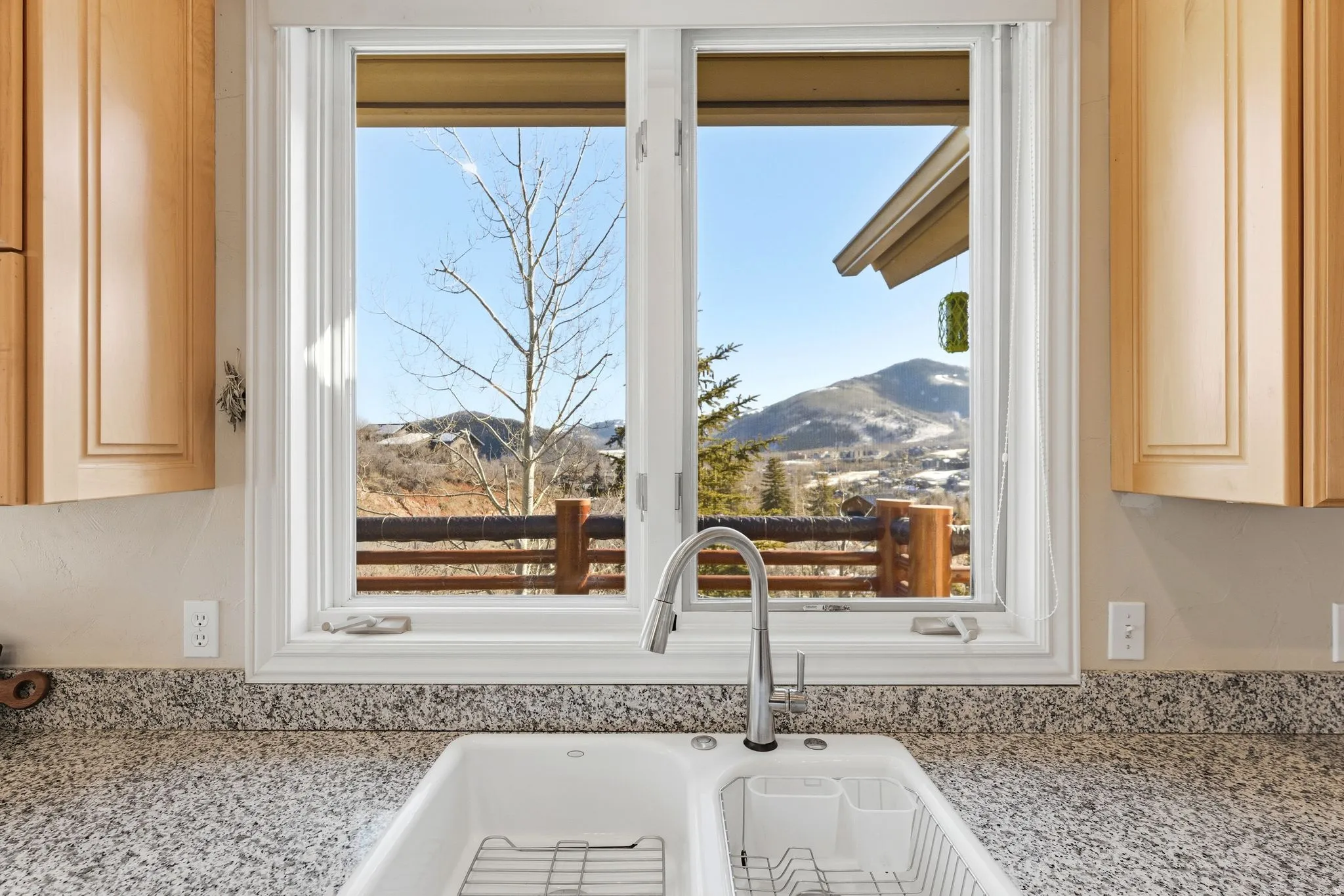 Kitchen view of light stone counters and light wood finish cabinets