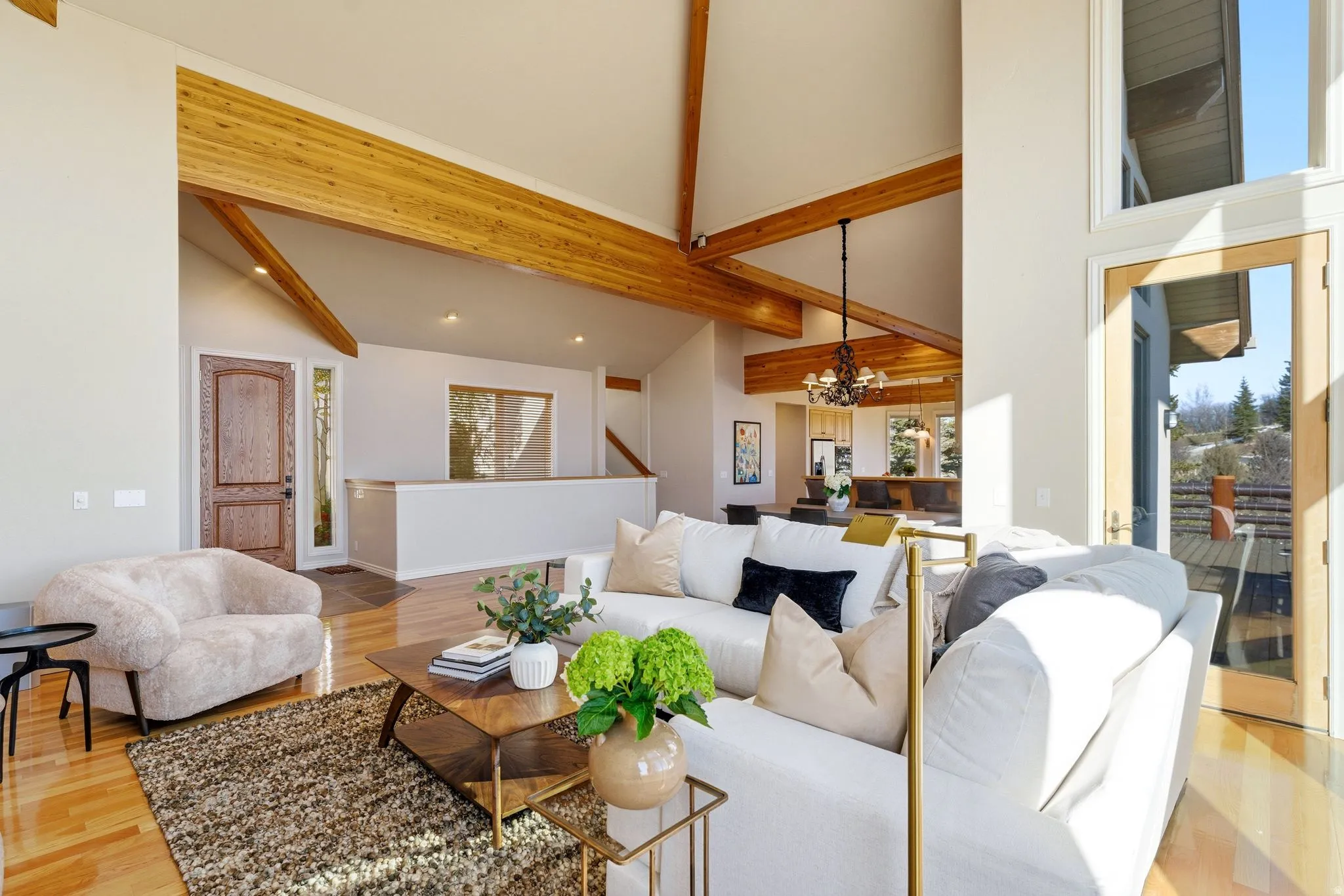 Living room featuring light wood-style flooring, hanging lights, healthy amount of natural light, and lofted ceiling