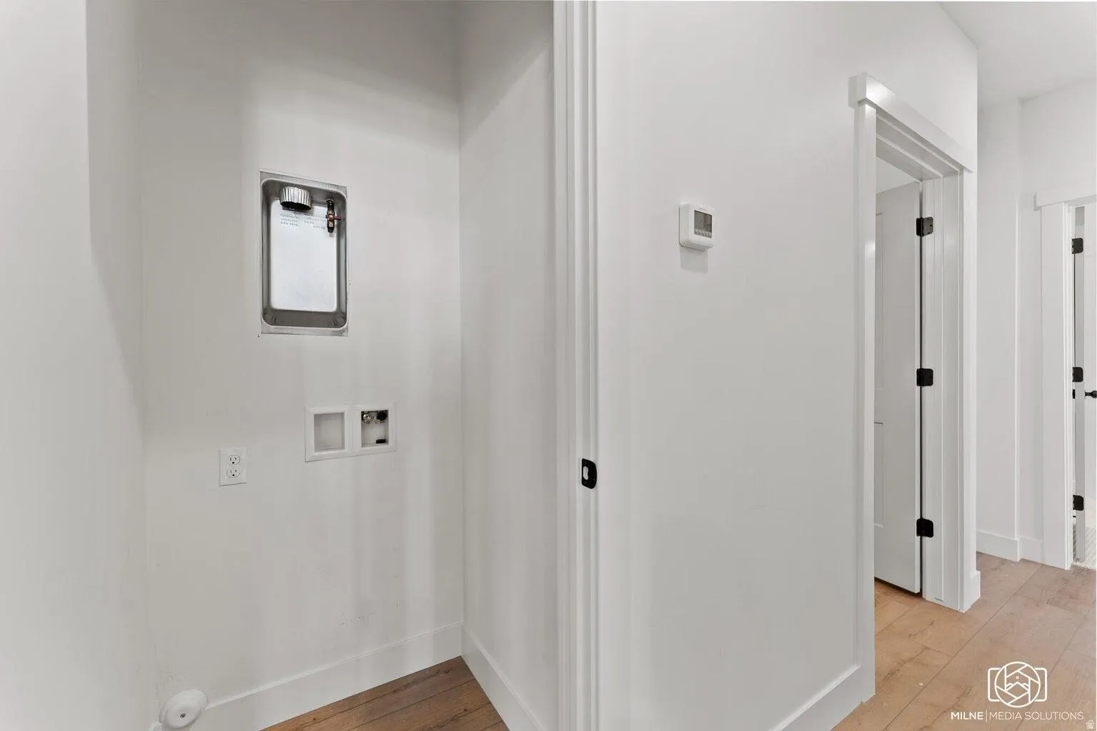 Laundry area with washer hookup and light wood finished floors