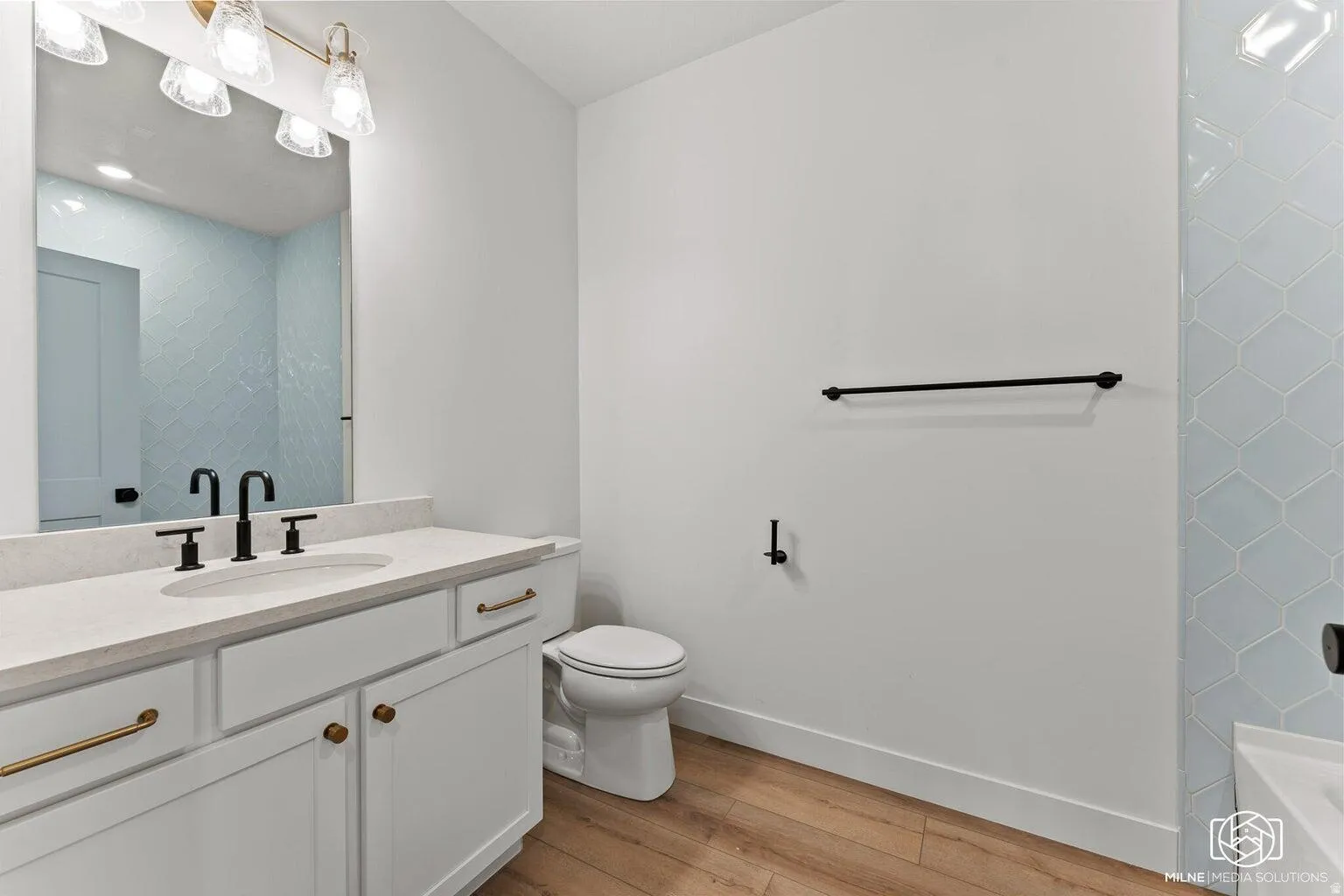 Bathroom with vanity, light wood-style flooring, and shower / washtub combination