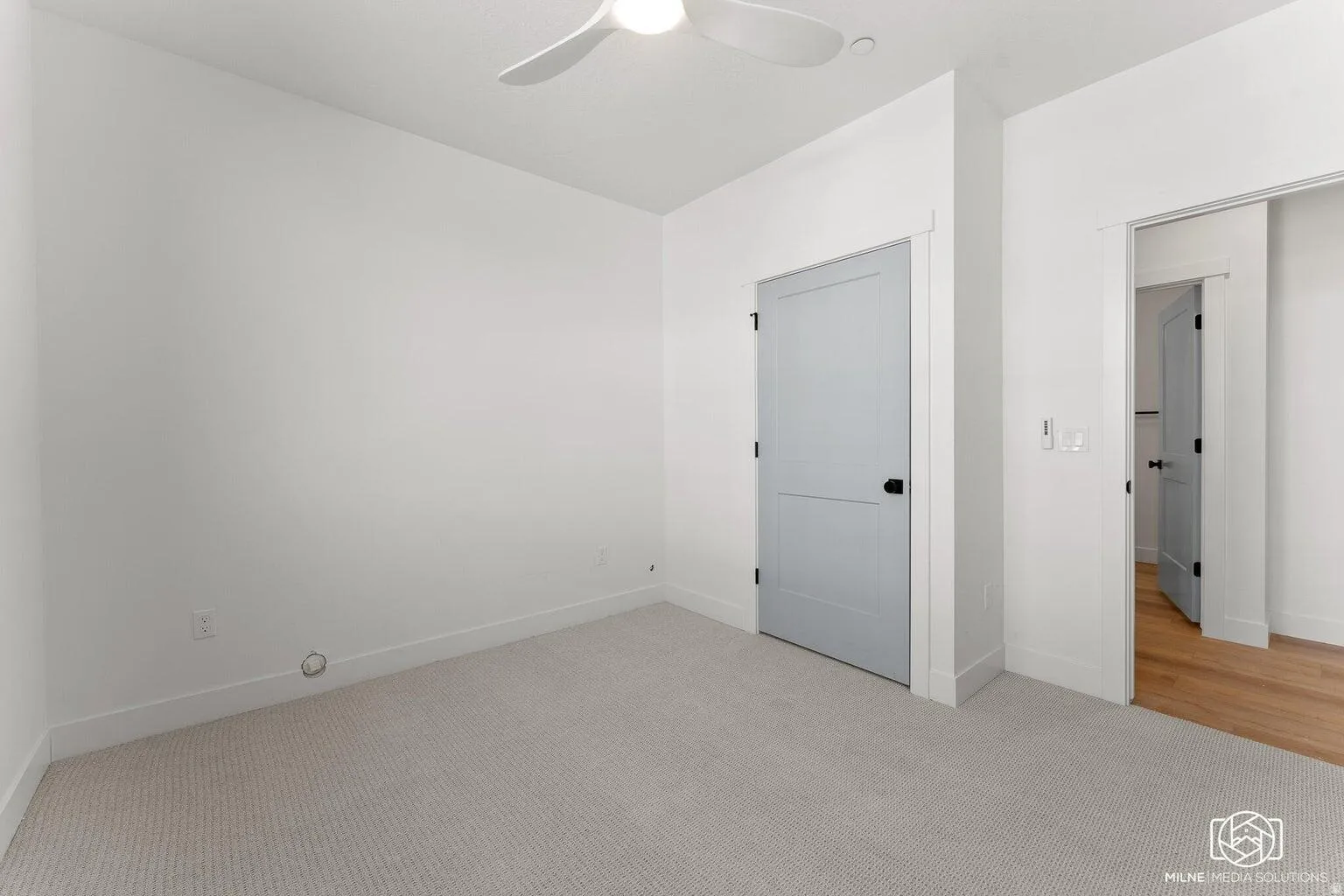 Unfurnished bedroom with light carpet and ceiling fan