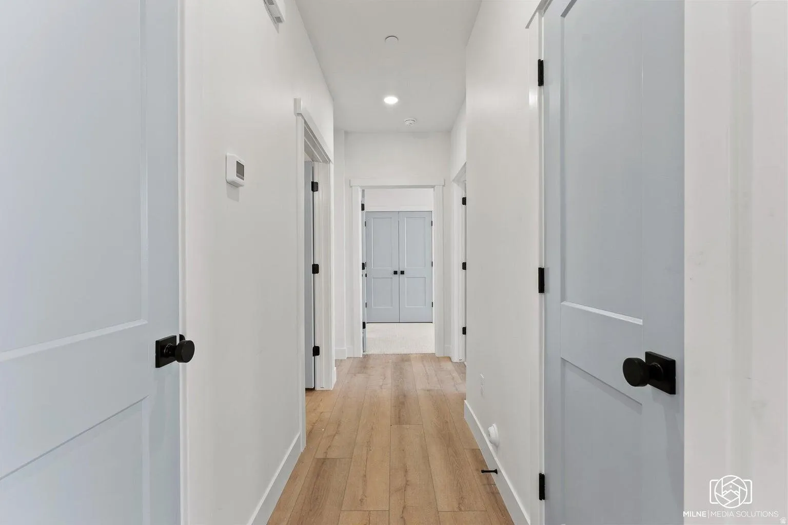 Hall featuring light wood finished floors and recessed lighting