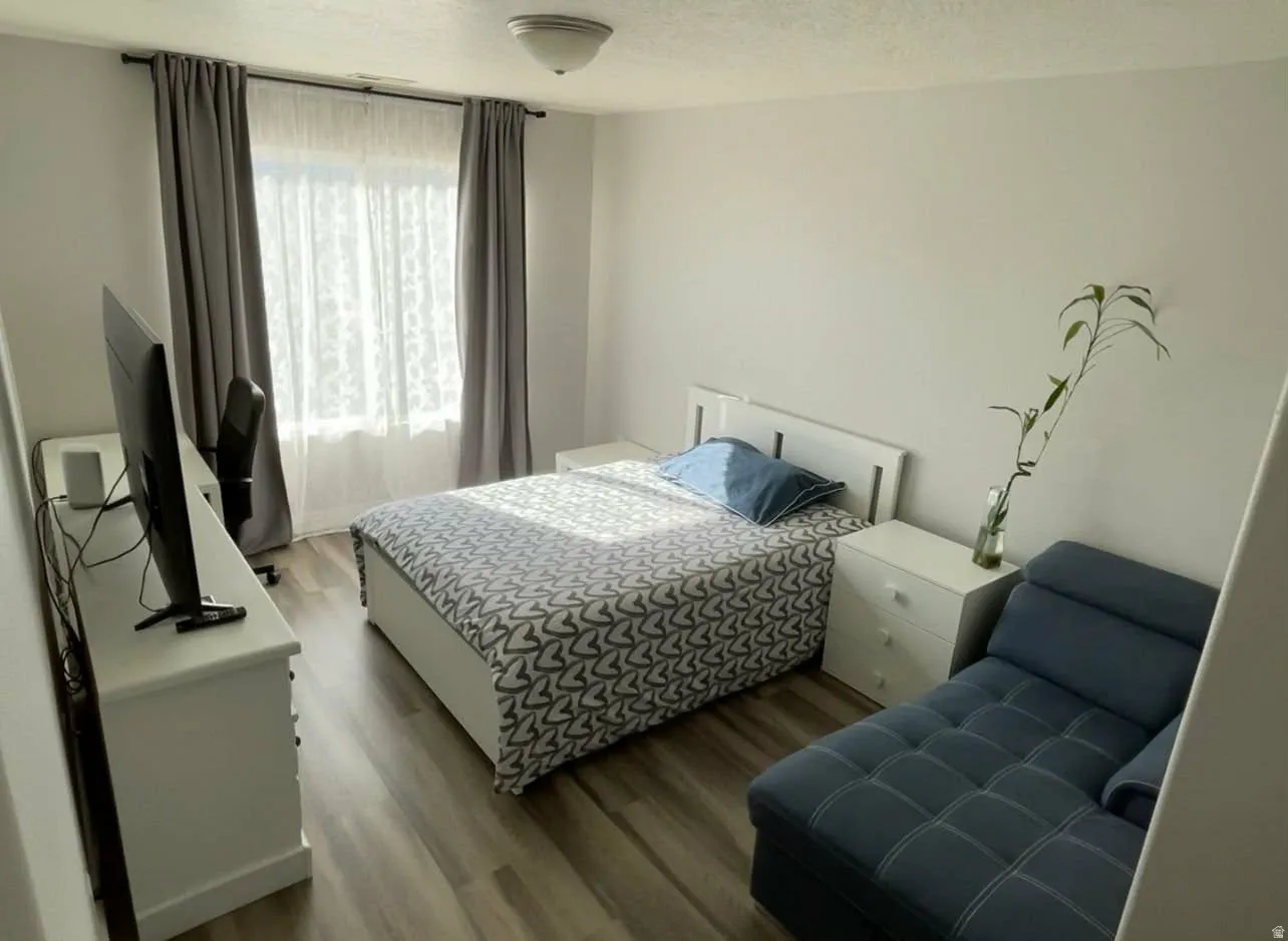 Bedroom featuring wood finished floors and a textured ceiling