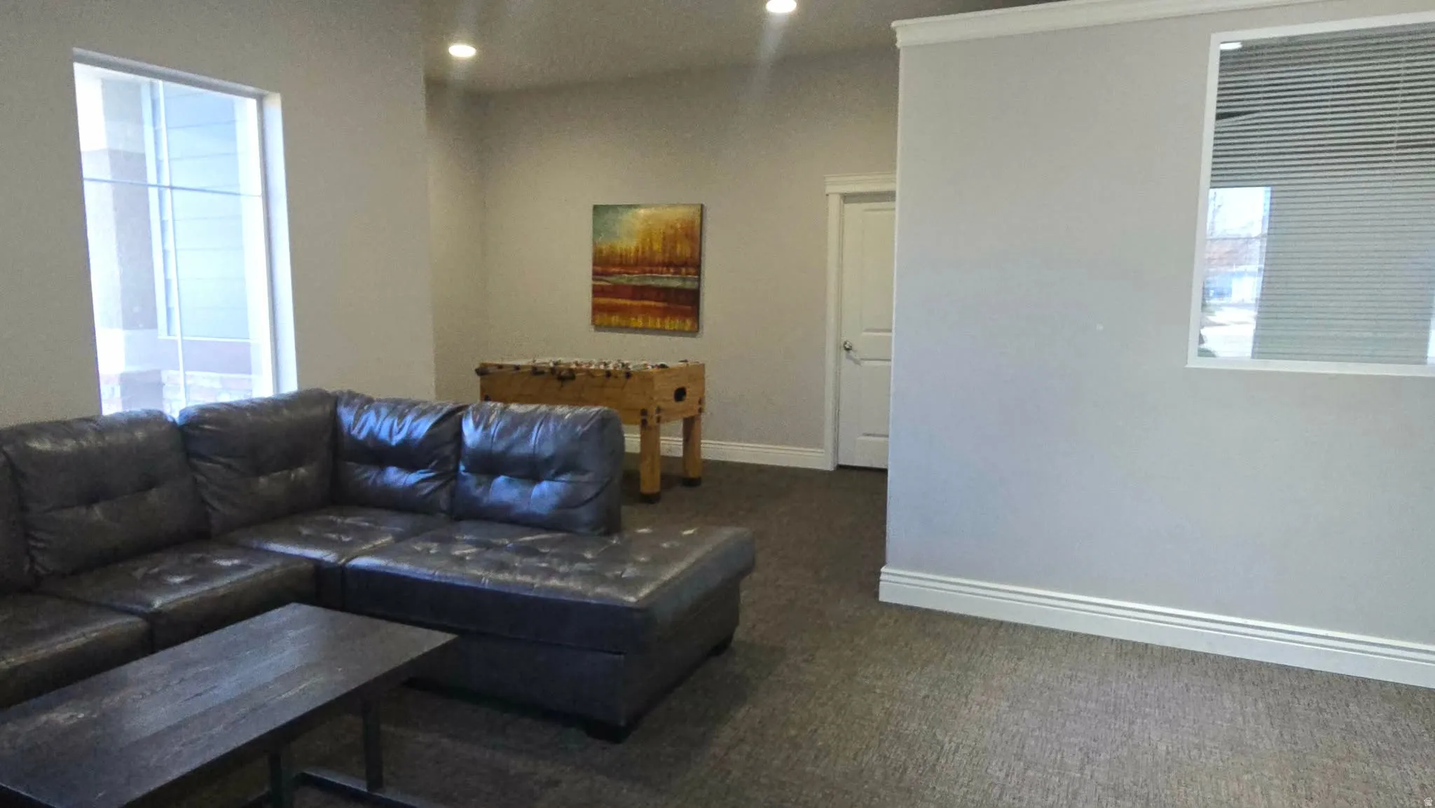 Living area with dark carpet and recessed lighting