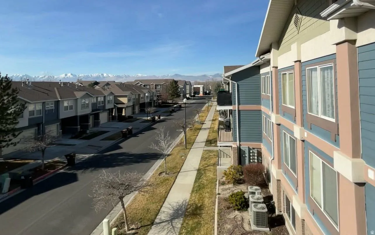 View of asphalt road with sidewalks, curbs, and a residential view