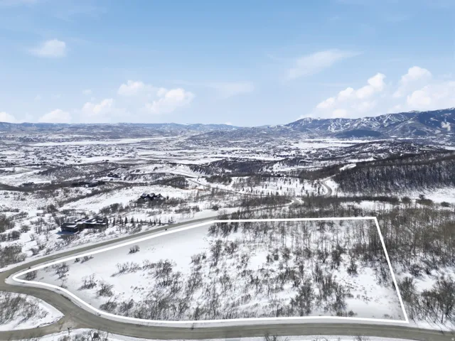 Snowy aerial view featuring a mountain view and property boundaries highlighted
