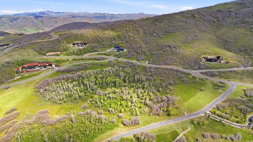 Expansive mountainous terrain featuring scattered residences and winding paved roads