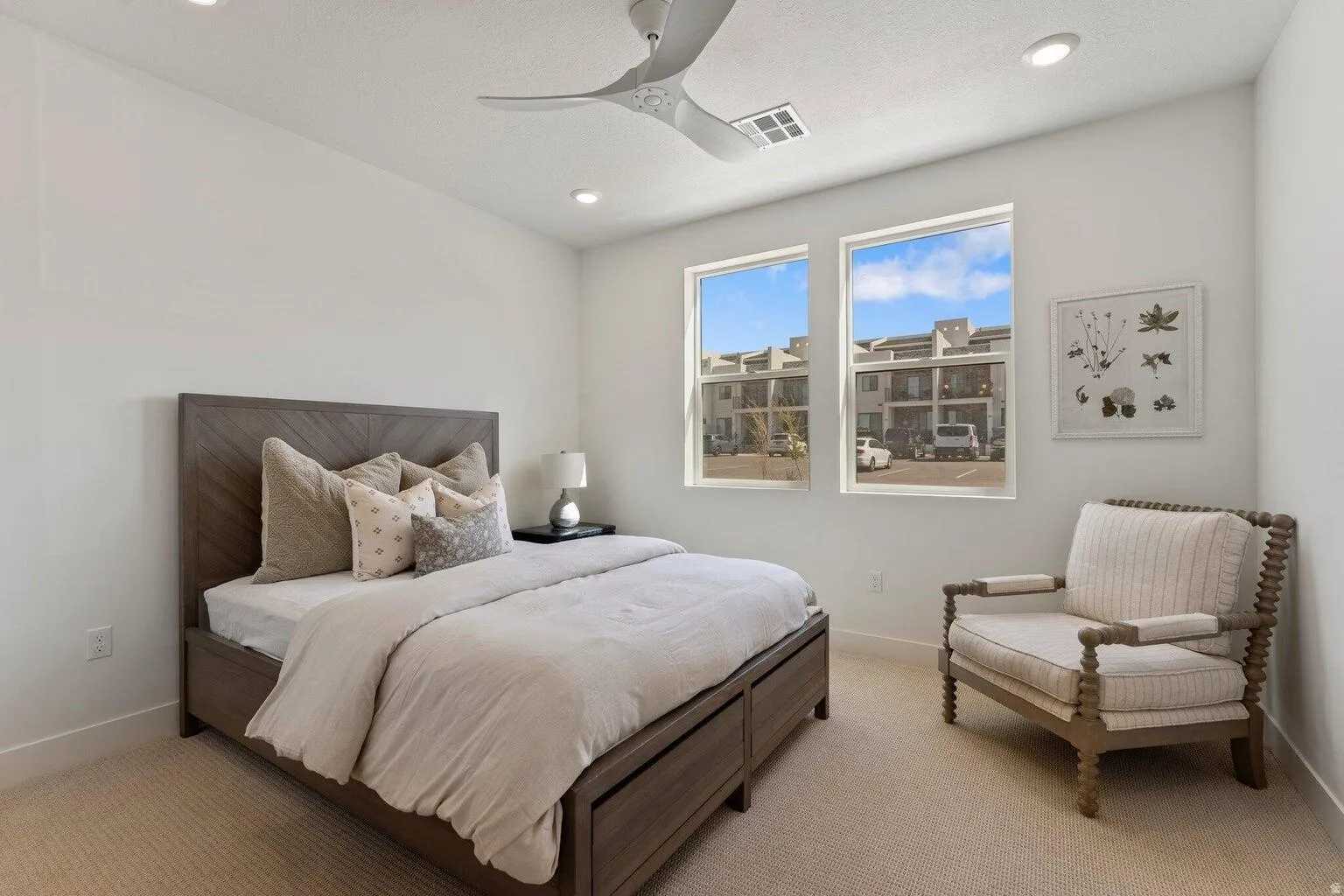Carpeted bedroom with a ceiling fan and recessed lighting