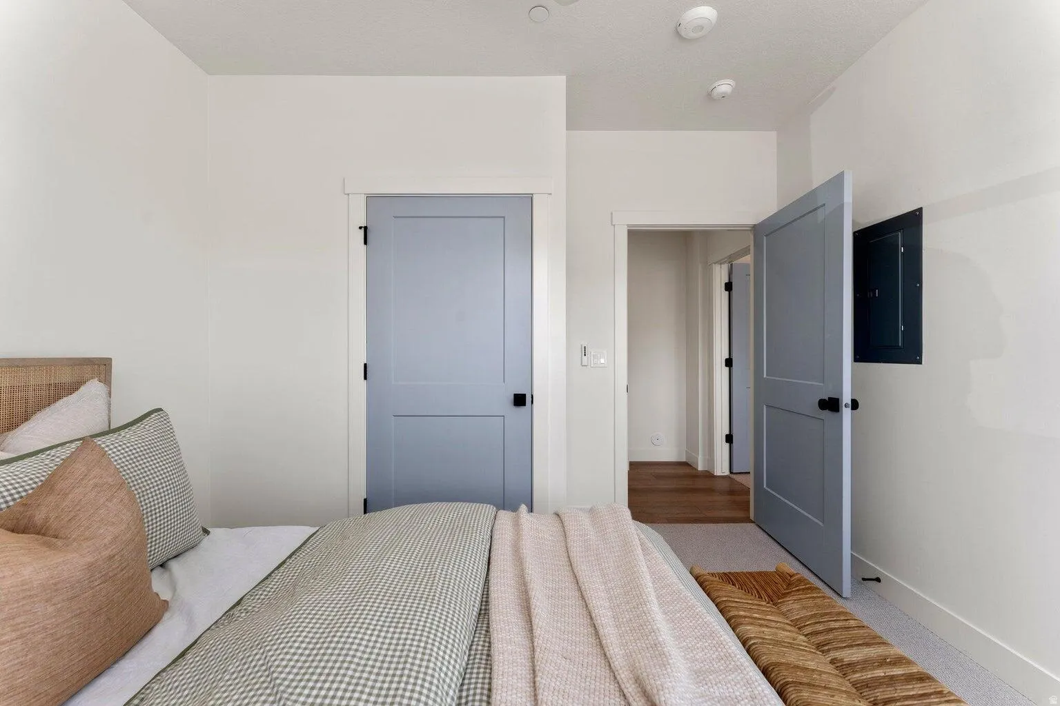 Carpeted bedroom featuring electric panel and baseboards