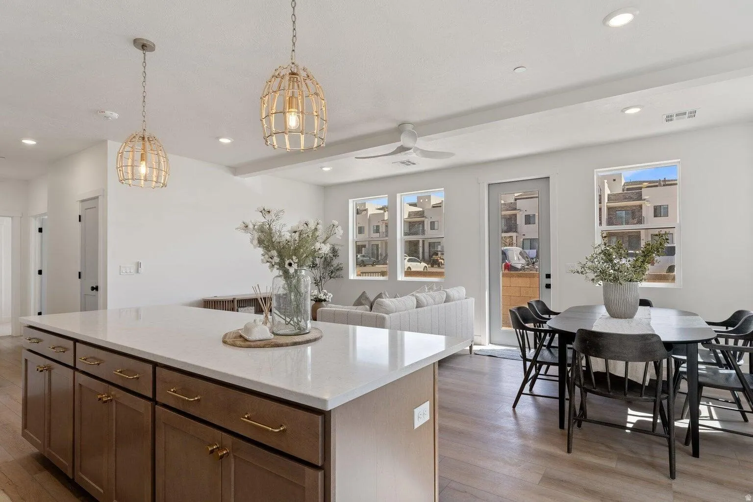 Kitchen with hanging light fixtures, ceiling fan, light wood finished floors, and a center island