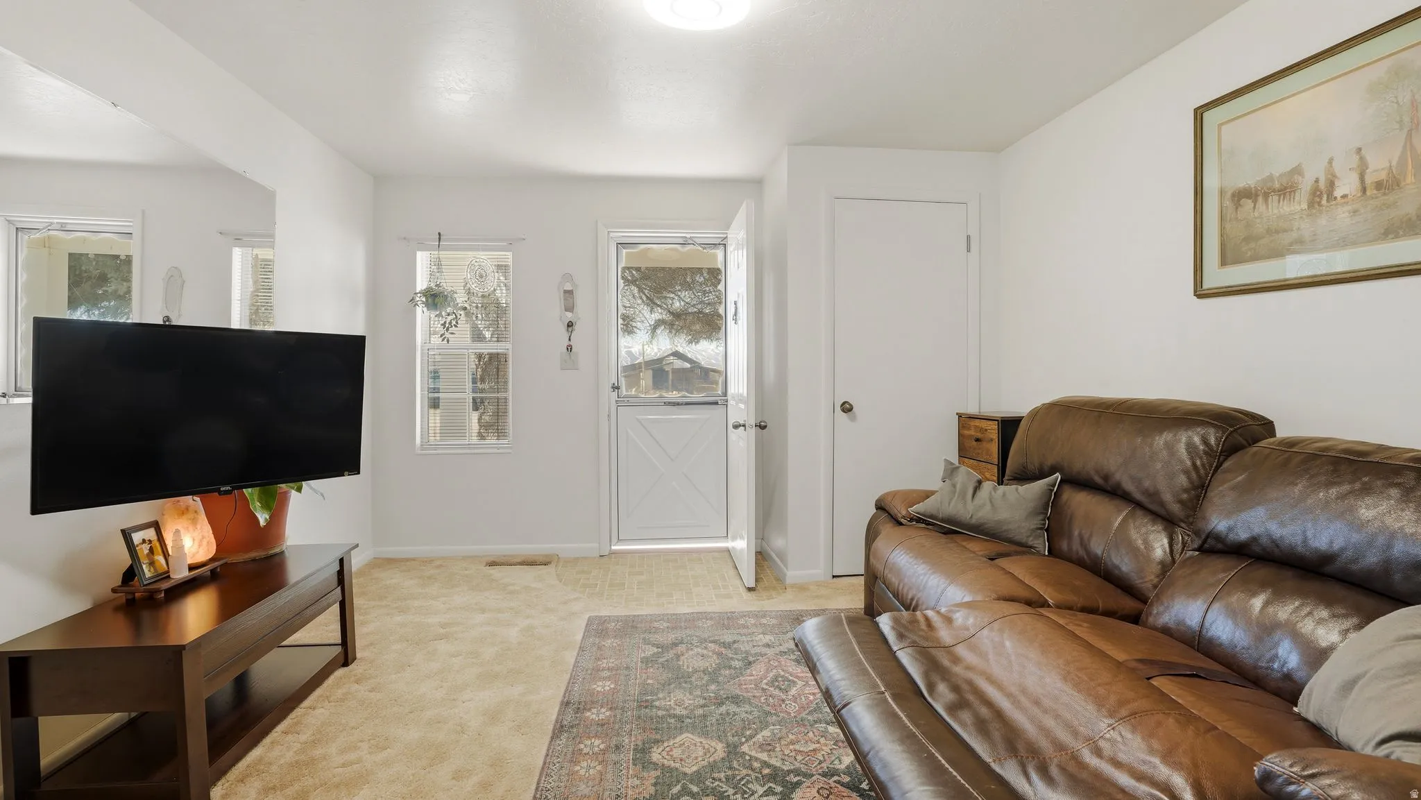 Living area with light colored carpet and baseboards