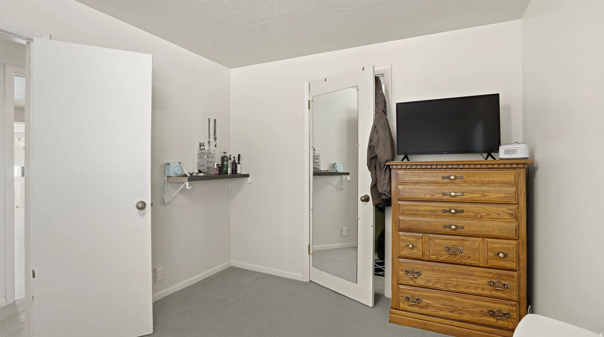 Bedroom with light colored carpet, a closet, and a textured ceiling