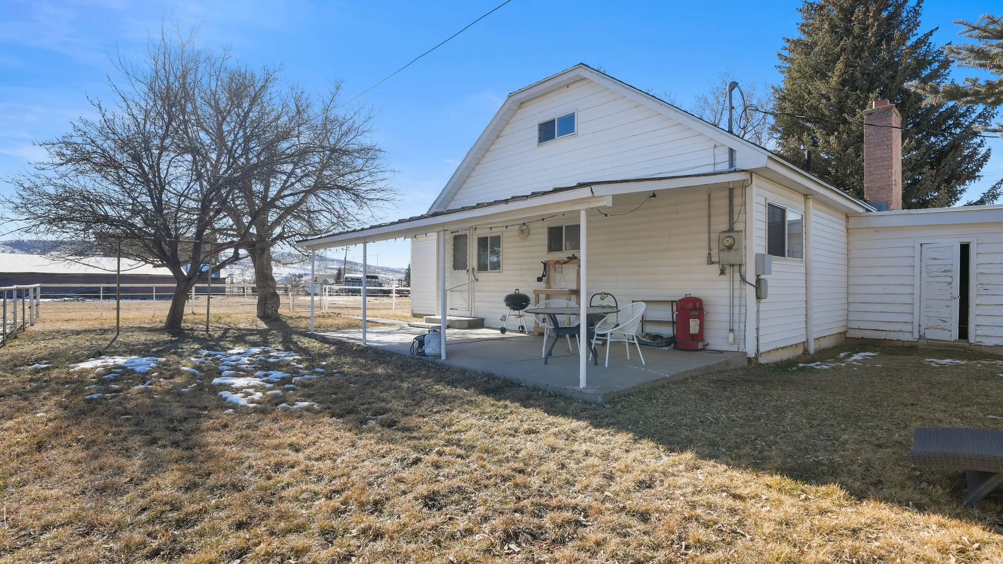 Back of house with a chimney and a patio