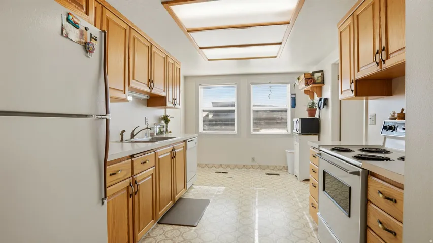 Kitchen featuring white appliances, light countertops, and light floors
