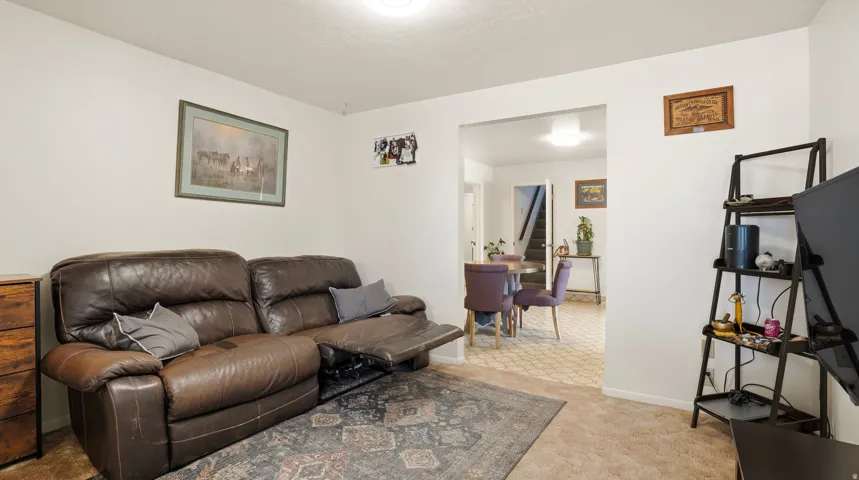 Living room with baseboards and light colored carpet
