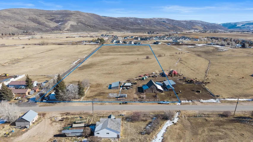 Aerial view of sparsely populated area featuring a mountain backdrop and property parcel outlined
