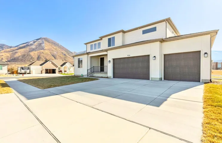 Traditional-style home with stucco siding, concrete driveway, and a mountain view