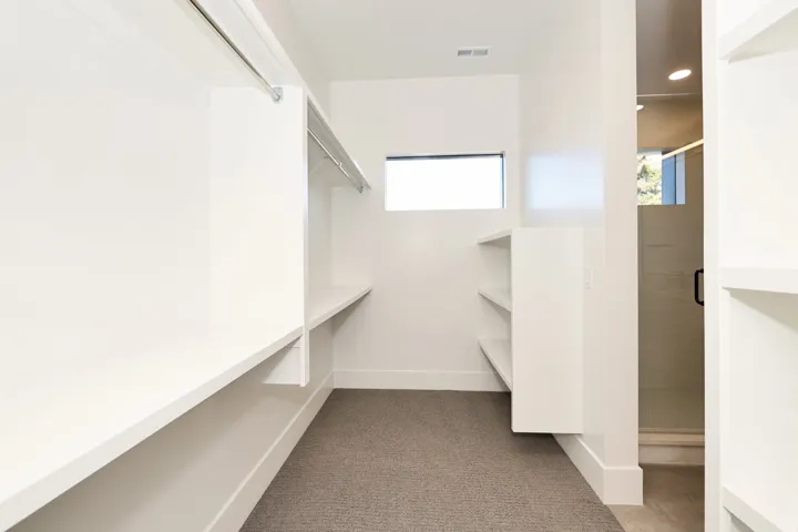 Walk in closet featuring dark carpet