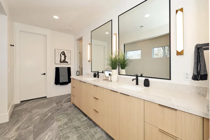 Bathroom with double vanity, recessed lighting, and dark marble finish floors
