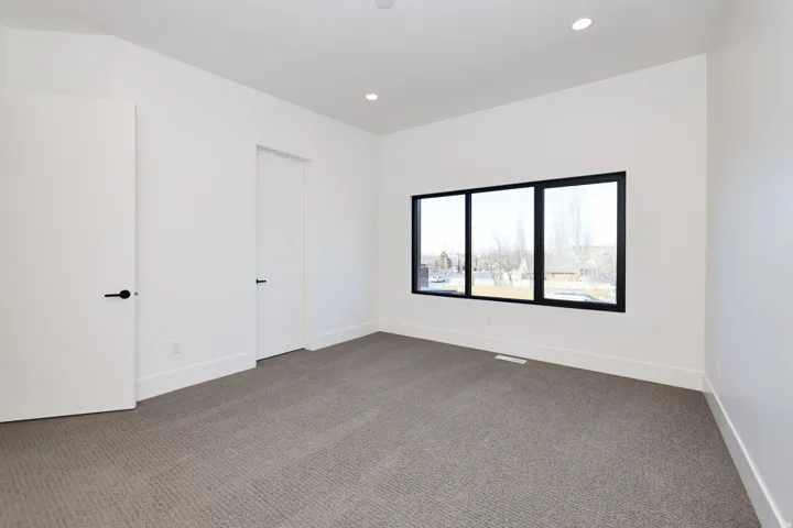 Carpeted empty room featuring baseboards and recessed lighting