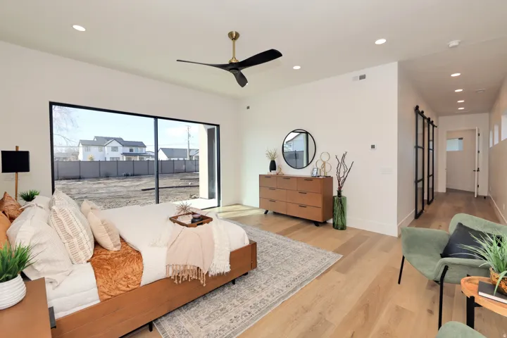 Bedroom featuring a barn door, recessed lighting, access to outside, light wood-type flooring, and a ceiling fan