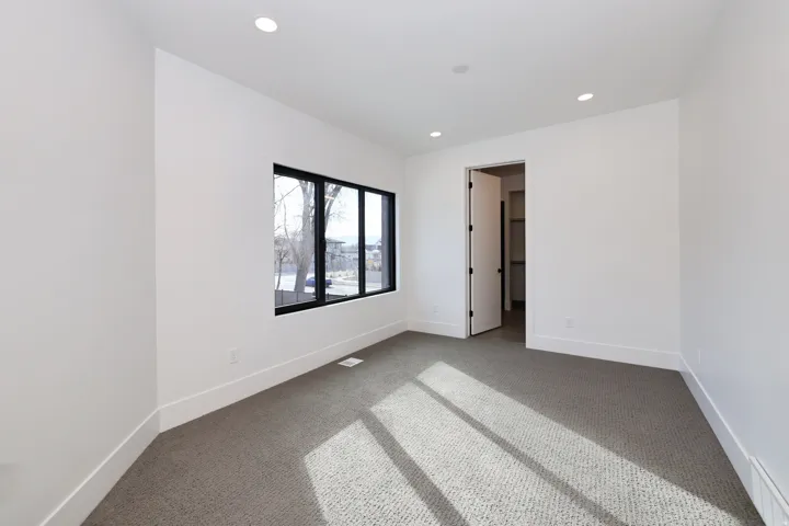 Unfurnished bedroom featuring carpet flooring, recessed lighting, and a baseboard radiator