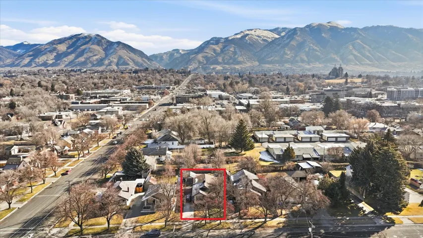 Aerial view of residential area featuring property boundaries highlighted and mountains