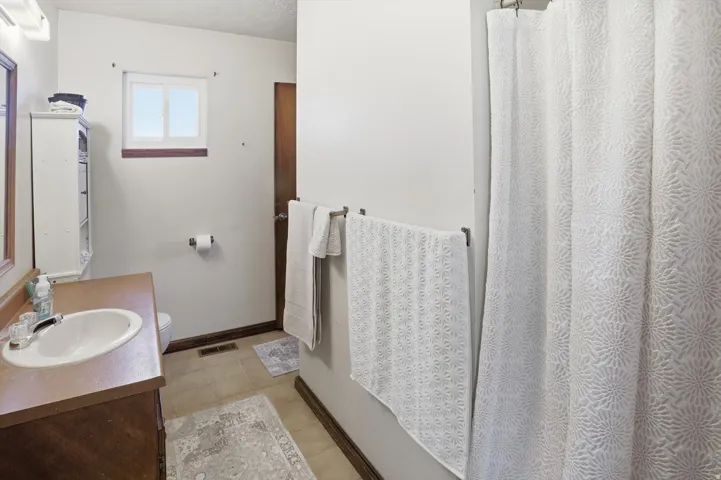 Bathroom featuring vanity, a shower with shower curtain, and light tile patterned floors