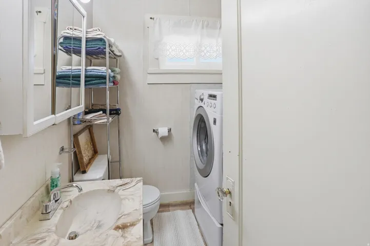Half bathroom with washer / dryer and vanity