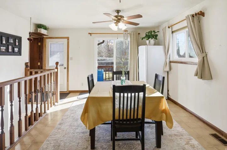 Dining space with ceiling fan and light tile patterned flooring