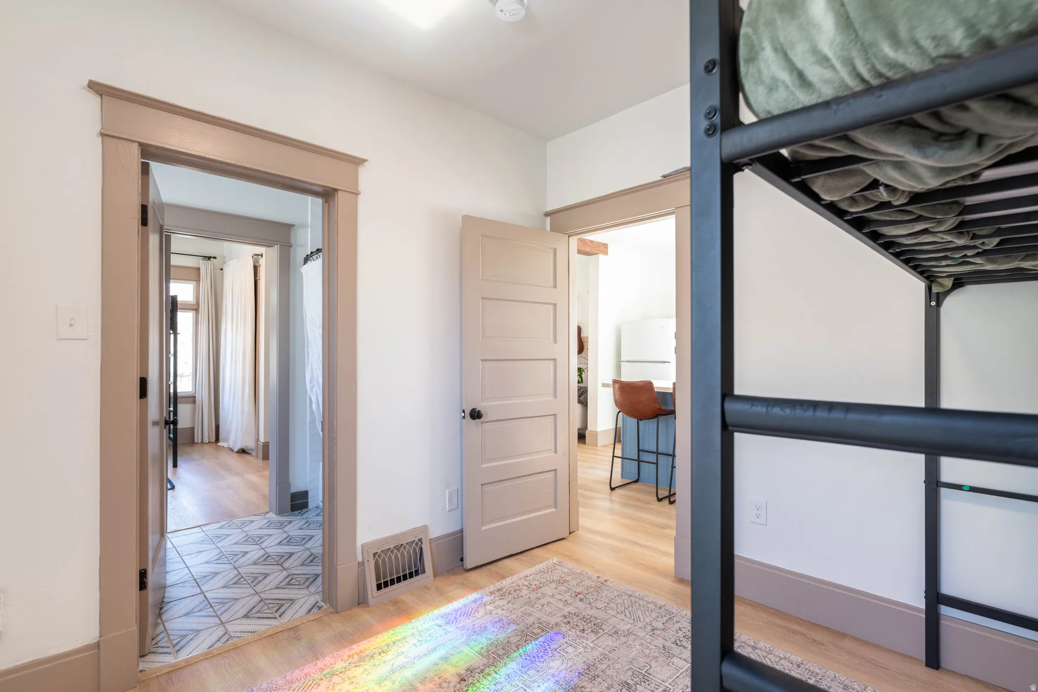 Bedroom with light wood finished floors and freestanding refrigerator