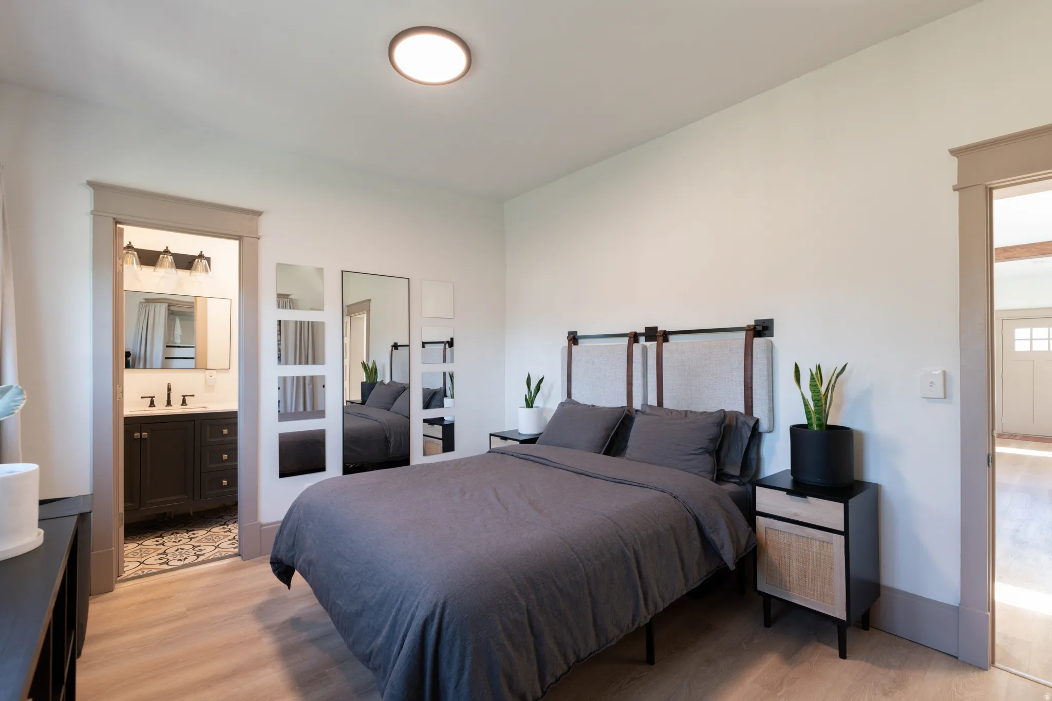 Bedroom with light wood finished floors and ensuite bath