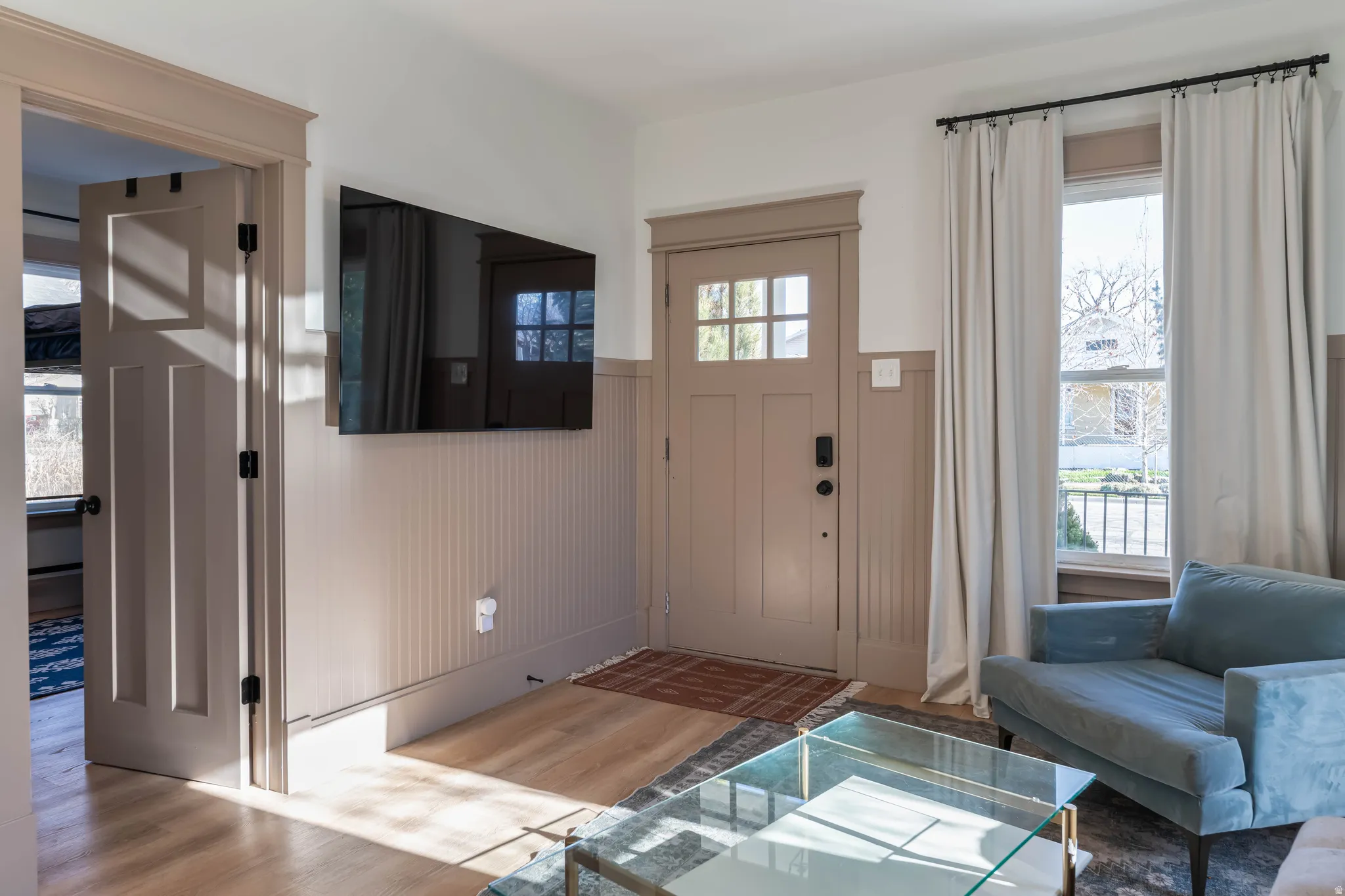 Foyer with a wainscoted wall, wood finished floors, plenty of natural light, and wooden walls
