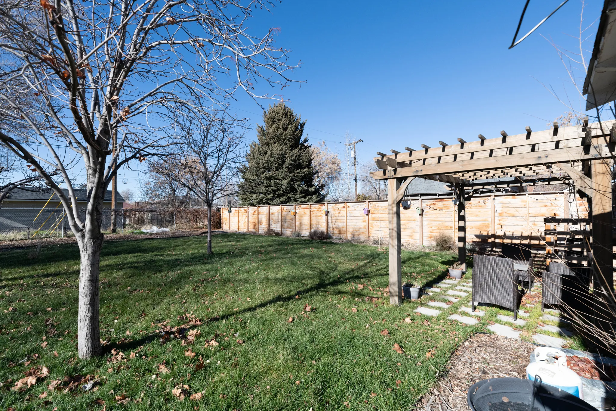 Fenced backyard with a pergola and a patio area