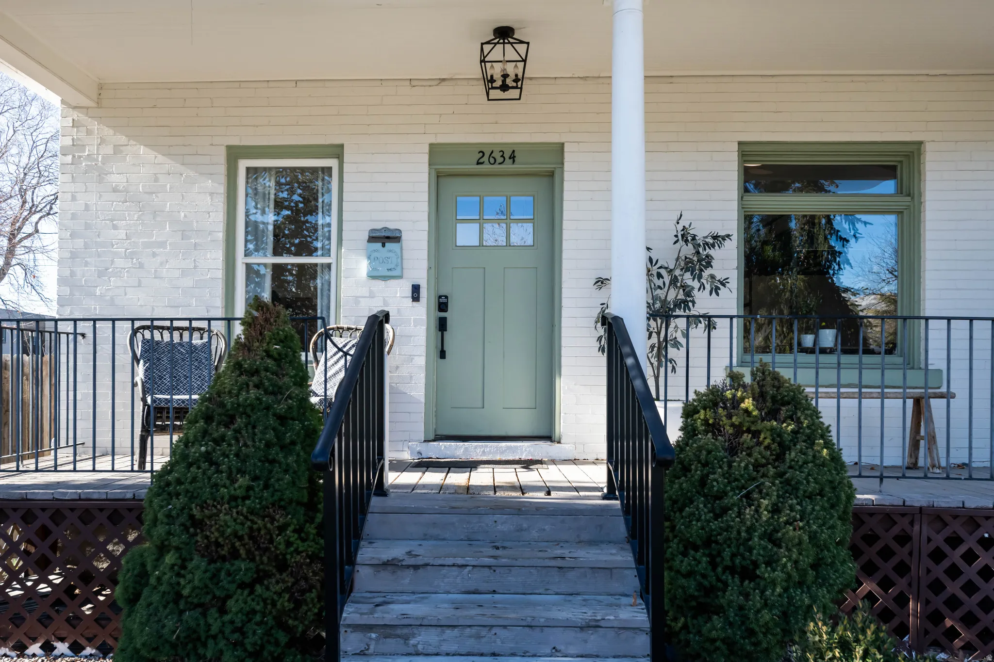 Property entrance featuring covered porch and brick siding