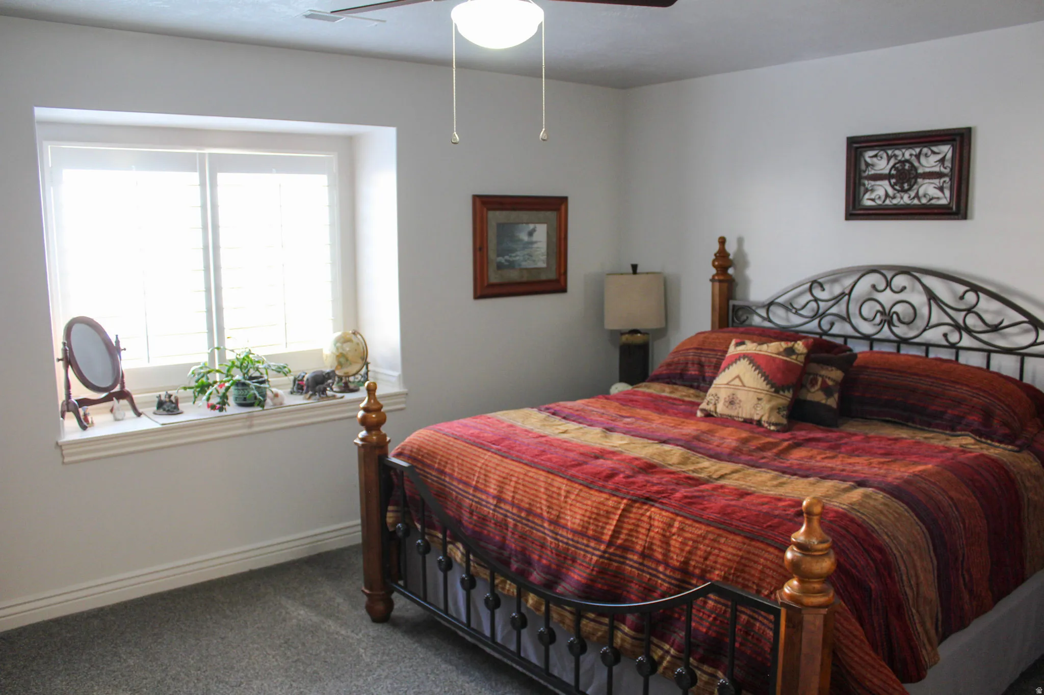 Carpeted bedroom featuring a ceiling fan and baseboards