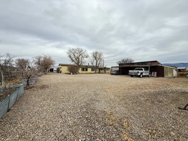 View of front of house featuring a carport and gravel driveway