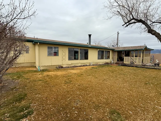 Back of property with a yard and a deck