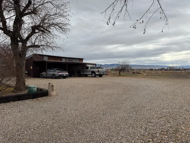 View of yard featuring a mountain view, a carport, and driveway